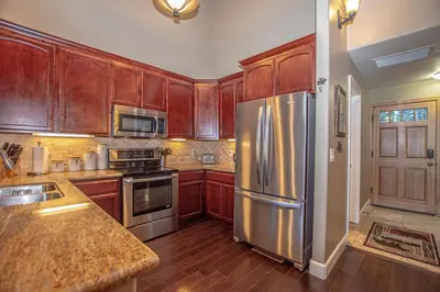 a kitchen with wooden cabinets and a stainless steel refrigerator at Weathertop By Hauserman Rentals in Tahoe City