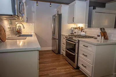 a kitchen with white cabinets and stainless steel appliances at Price Haus By Hauserman Rentals in Tahoe City