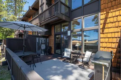 a patio with a table and chairs and an umbrella at Star Harbor # 6 By Hauserman Rentals in Tahoe City