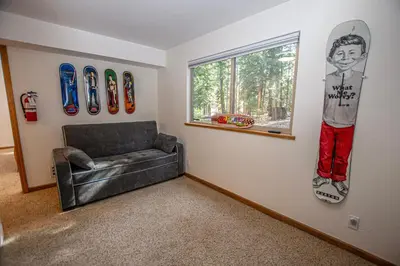 a living room with a couch and snowboards on the wall at Daly's Digs By Hauserman Rentals in Tahoe City