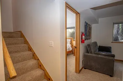 a living room with a staircase and a chair at Daly's Digs By Hauserman Rentals in Tahoe City