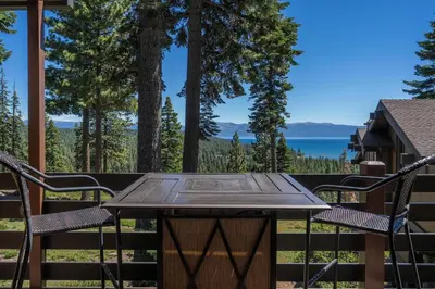 a table and chairs on a deck with a view of the water at Rocky Ridge # 04 By Hauserman Rentals in Tahoe City