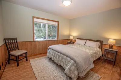 a bedroom with a bed and a chair and a window at Knobcone Cabin by Hauserman Rental Group in Tahoma