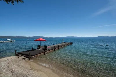 a person sitting under an umbrella on a pier at Peaceful Waters By Hauserman Rentals in Tahoma