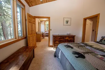 a bedroom with a bed and a wooden dresser at KT22 View By Hauserman Rentals in Olympic Valley