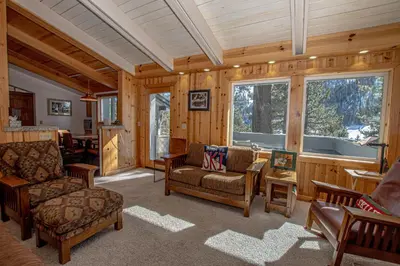 a living room with wooden walls and a large window at KT22 View By Hauserman Rentals in Olympic Valley