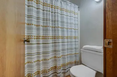 a bathroom with a toilet and a shower curtain at Cozy Condo with Fireplace - Tamarack 3 in Bear Valley
