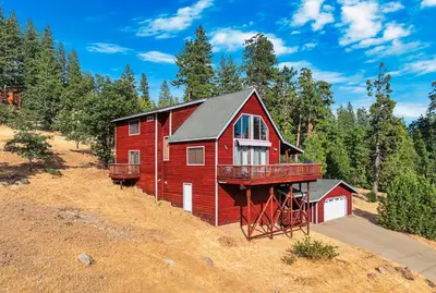 a red house on the side of a hill at Prasad Retreat - Sunny Home with Deck & Air Hockey home in Arnold