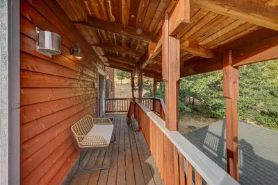 a porch of a wooden house with a chair at Prasad Retreat - Sunny Home with Deck & Air Hockey home in Arnold