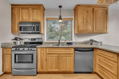 a kitchen with wooden cabinets and stainless steel appliances at Prasad Retreat - Sunny Home with Deck & Air Hockey home in Arnold