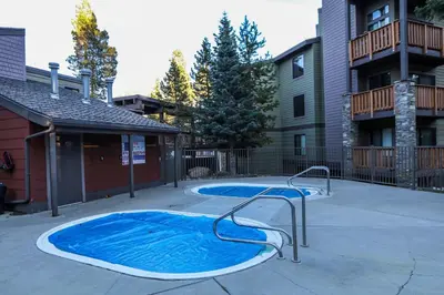 a small swimming pool in a courtyard next to a building at Summit #243 condo in Mammoth Lakes