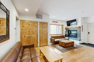 a living room with a couch and a fireplace at Olympic Pines Lodge in Olympic Valley