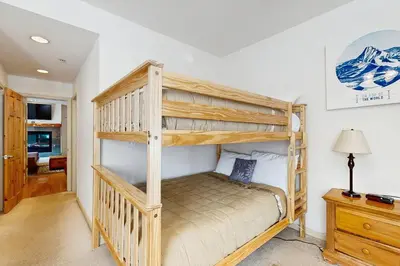 a bedroom with two bunk beds and a desk at Olympic Pines Lodge in Olympic Valley
