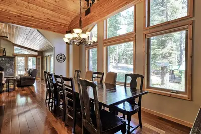 a dining room with a table and some windows at Tahoma Family Home in Tahoma