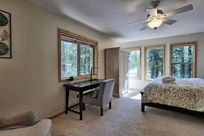 a bedroom with a desk and a bed and windows at Tahoma Family Home in Tahoma