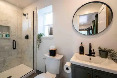 a bathroom with a toilet and a shower and a mirror at Columbia Cabins Cabin 2 in Sonora