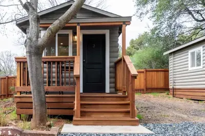 a tiny house with a porch and a deck at Columbia Cabins Cabin 3 in Sonora