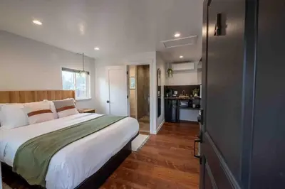 a bedroom with a large bed and a kitchen at Columbia Cabins Cabin 4 in Sonora