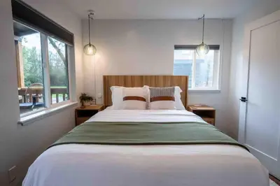 a bedroom with a large bed with two windows at Columbia Cabins Cabin 4 in Sonora