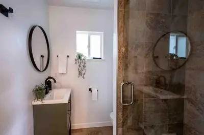 a bathroom with a shower and a sink and a mirror at Columbia Cabins Cabin 5 in Sonora