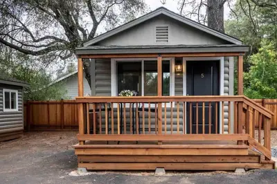 a small house with a large deck at Columbia Cabins Cabin 5 in Sonora
