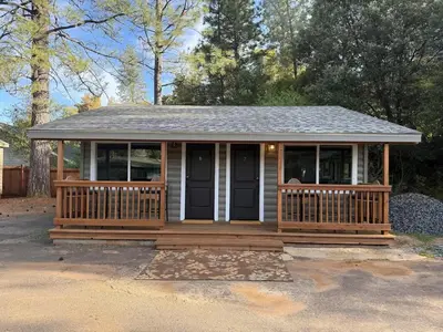 a small house with a porch and a roof at Columbia Cabins Cabin 7 in Sonora