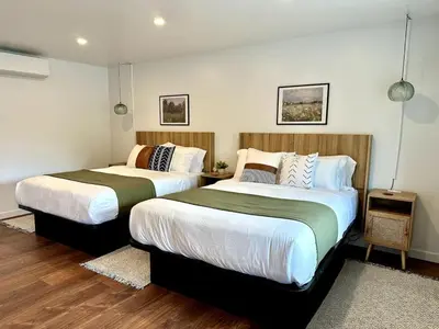 two beds in a room with wood floors at Columbia Cabins Cabin 9 in Sonora