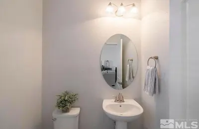 a bathroom with a sink and a mirror and a toilet at Local 3BD 3BA with WiFi Parking in Carson City