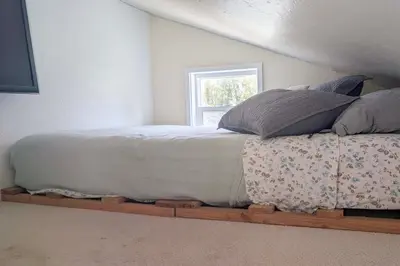 a bed with pillows on a wooden platform in a bedroom at 11 Mi to Heavenly Resort Pet-Friendly Tiny Home in Gardnerville