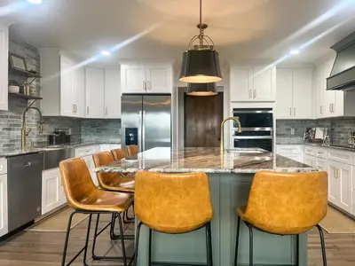 a kitchen with white cabinets and a large island with chairs at Yosemite Family Lodge I Sleeps 11 I Game Room in Oakhurst