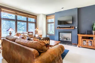 a living room with a leather couch and a fireplace at Solstice 8 in Mammoth Lakes