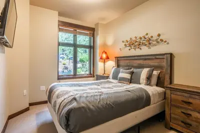 a bedroom with a large bed and a window at Solstice 8 in Mammoth Lakes