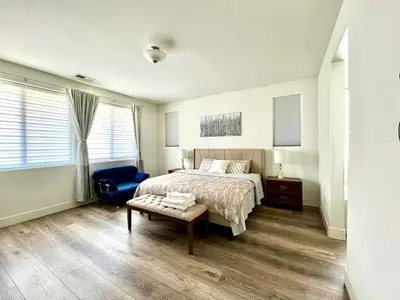 a bedroom with a bed and a blue chair at Spacious, bright and cozy space