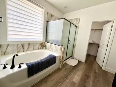 a bathroom with a large tub and a window at Spacious, bright and cozy space