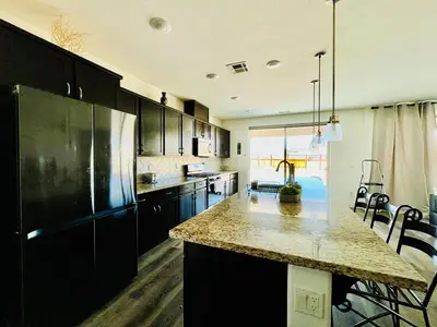 a kitchen with a black refrigerator and a counter top at Spacious, bright and cozy space