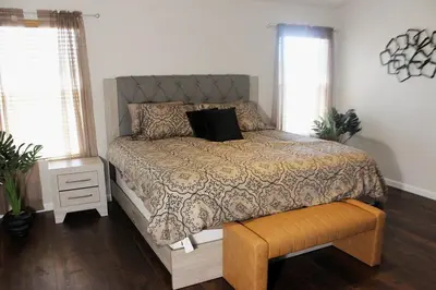 a bedroom with a bed with a comforter and a bench at Luxurious 5-Bedroom Retreat with Saltwater Pool and Spa in Elk Grove