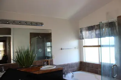 a bathroom with a tub and a sink and a mirror at Luxurious 5-Bedroom Retreat with Saltwater Pool and Spa in Elk Grove