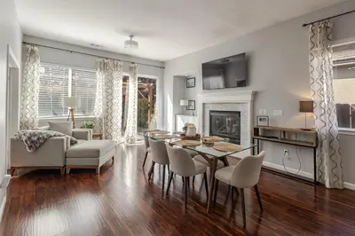 a living room with a table and chairs and a fireplace at New Reno Retreat 72 Inch TV Office Patio Views in Reno