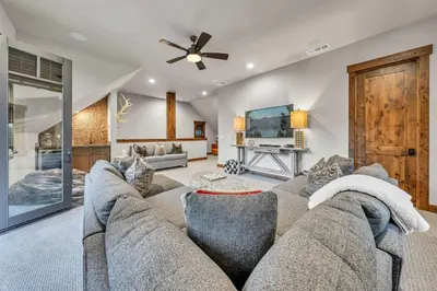 a living room with a couch and a flat screen tv at Schaffers Mill Escape Golf Views and Near Skiing in Truckee