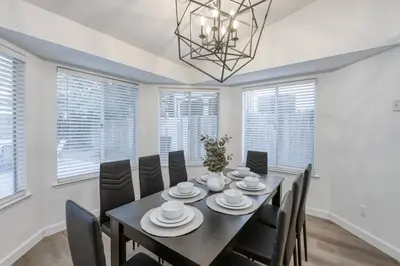 a dining room with a table and chairs and a chandelier at Clovis Retreat Hottub & Firepit in Clovis
