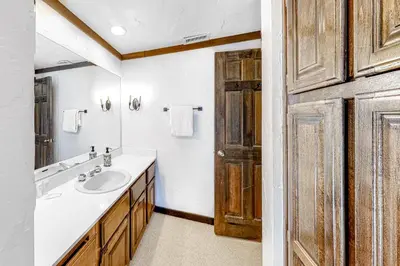 a bathroom with a sink and a wooden door at Tavern 16 in Olympic Valley