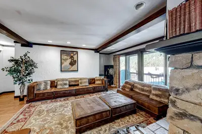 a living room with leather furniture and a fireplace at Tavern 16 in Olympic Valley