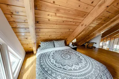 a bedroom with a large bed in a room with wooden walls at Sierra Townhome in Incline Village