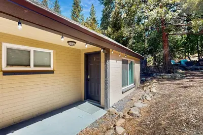 a yellow house with a door and a yard at The Chalet at Kings Beach Unit 7 in Kings Beach