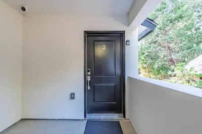 a black door in a white room with a window at The White House Coveted Triplex Near Lake