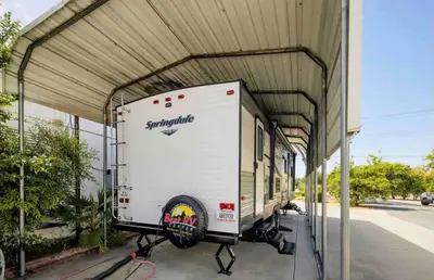 a large white truck parked in a garage at Parked RV Travel Trailer Getaway Wi-Fi with Hookups in Fresno