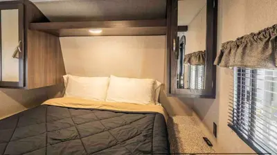 a small bed in a small room with a window at Parked RV Travel Trailer Getaway Wi-Fi with Hookups in Fresno