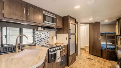 a kitchen with a sink and a stove at Parked RV Travel Trailer Getaway Wi-Fi with Hookups in Fresno
