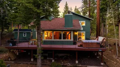 a house with a wrap around deck in the woods at Year-Round Tahoe Escape with Hot Tub Outdoor Dining Timberline Haven by AvantStay in Tahoe Vista