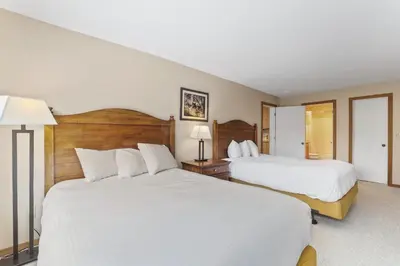 two beds in a hotel room with white sheets at 2 Bedroom Kirkwood Condo – Across the Street from Village condo in Kirkwood